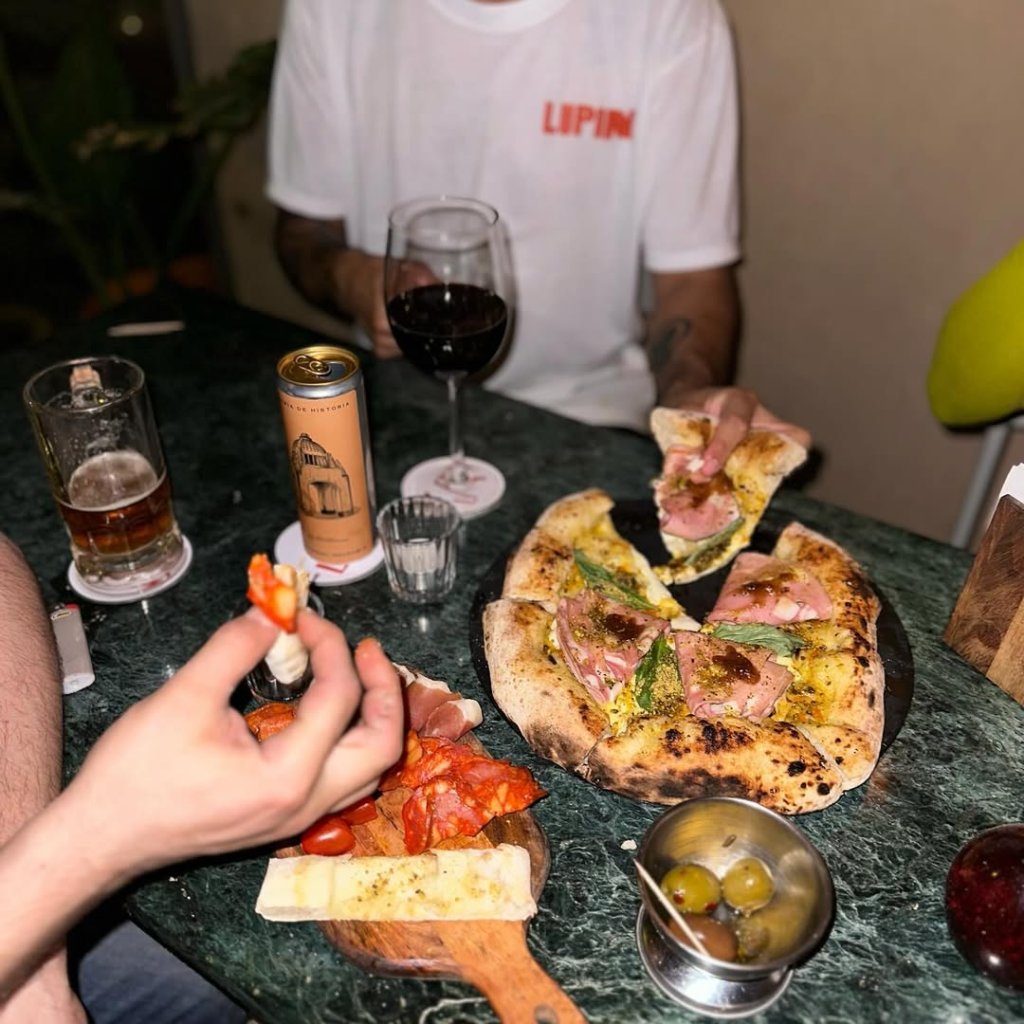 Además de contar con una cuidada selección de vinos, también hay pizzas.